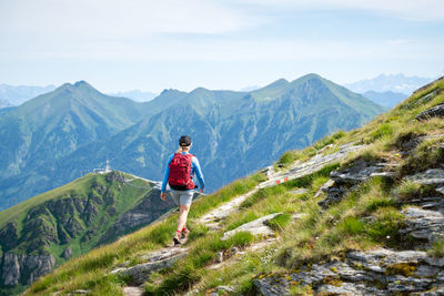 Rear view of man on mountain against sky