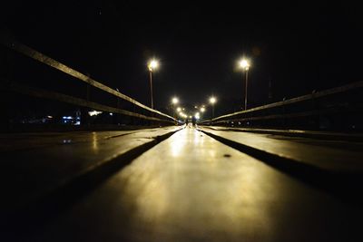 Illuminated bridge over road at night