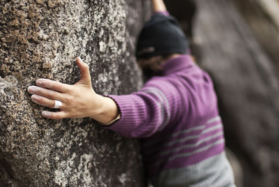 Rear view of person climbing rock