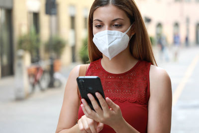 Portrait of young woman using mobile phone