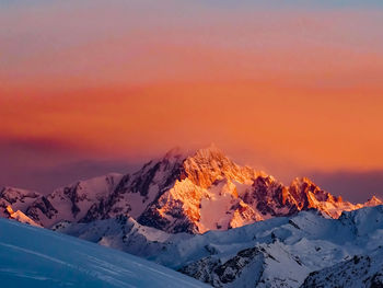 Scenic view of snowcapped mountains against sky during sunset