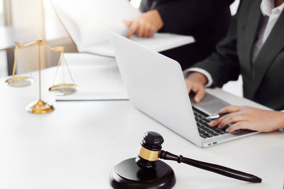 Midsection of man using mobile phone on table