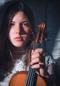 Portrait of beautiful young woman holding violin