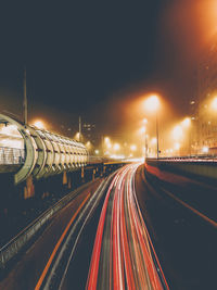 Light trails on road against sky at night