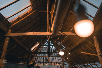 Low angle view of illuminated pendant lights hanging from ceiling