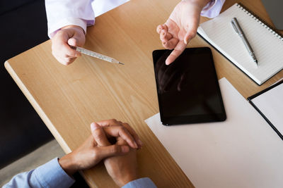 High angle view of man reading book on table