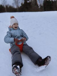 Low section of woman skiing on snow covered field