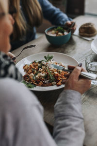 Midsection of woman holding food on table