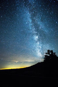 Silhouette hill against milky way in starry sky at dusk