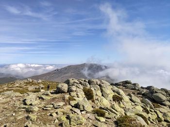 Hiking on the mountain peak with fog and sea of clouds over the horizon