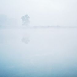 Scenic view of landscape against sky during foggy weather