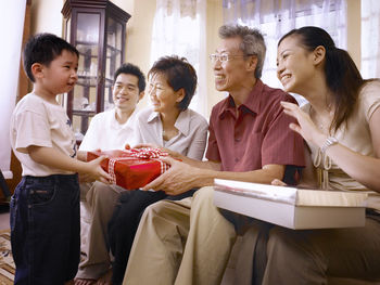 Family giving gift to boy at home