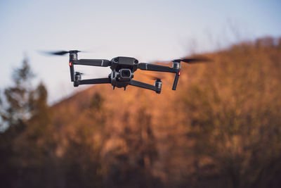 Low-angle view of a professional camera drone/quadrocopter at sunset