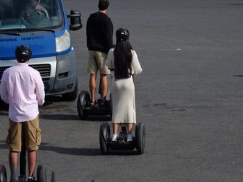 Rear view of people standing on road