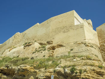 Low angle view of built structure against clear blue sky