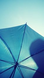 Low angle view of umbrella against clear blue sky