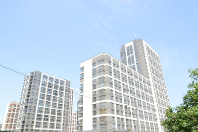 Low angle view of modern buildings against clear blue sky
