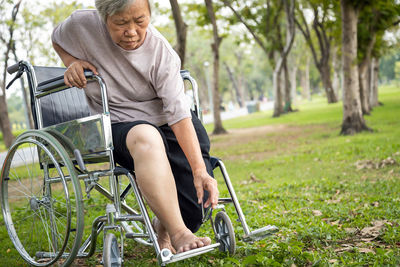 Senior woman sitting on wheelchair at park