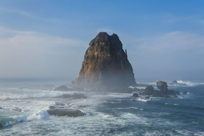 Rock formation in sea against sky