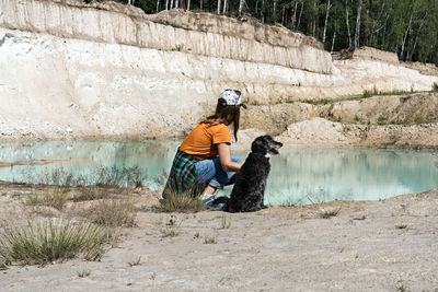Man sitting on rock by lake