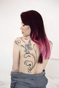 Portrait of woman standing against wall