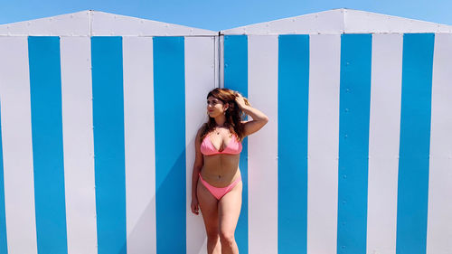 Woman standing against blue wall