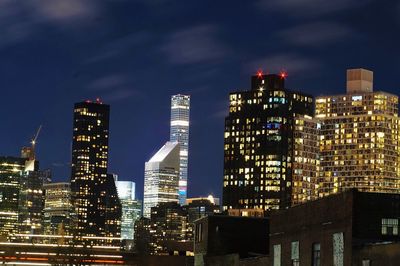 Illuminated cityscape against sky at night