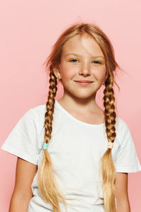 Portrait of young woman against pink background