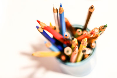 High angle view of colored pencils in container on white background