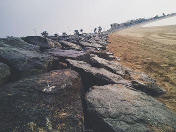 Rock formation on beach against clear sky