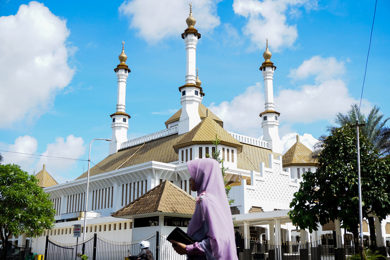 WOMAN WITH CATHEDRAL AGAINST SKY