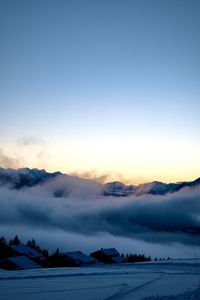 Scenic view of snow covered mountains against sky during sunset