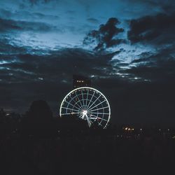 Illuminated ferris wheel against sky at night