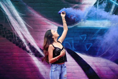 Full length of woman standing against wall