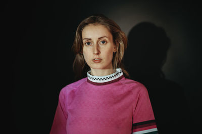 Portrait of a beautiful young woman over black background