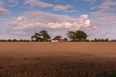 Field of straw stubble with house on the horizon