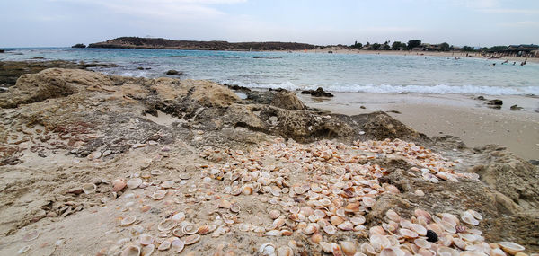 Scenic view of rocks on beach against sky