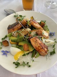 A tasty looking dish with fried salmon, egg, avocado and herbs at a zambian restaurant in lilayi.