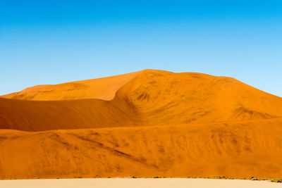 Scenic view of mountains against blue sky