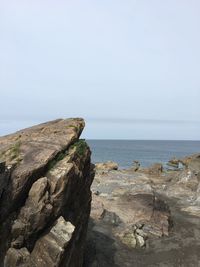 Rock formation on beach against clear sky