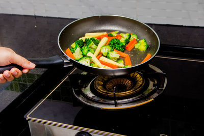 High angle view of person preparing food in pan