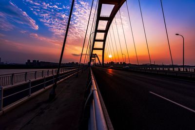 Silhouette fuyuan lu bridge over river against sky during sunset