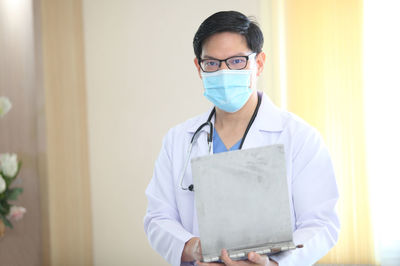 Portrait of doctor with digital tablet standing in hospital