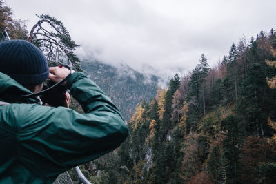 Man holding plants in forest