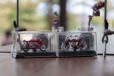Close-up of motorcycles in glass containers on table