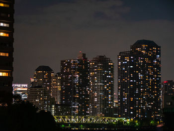 Illuminated buildings in city against sky at night