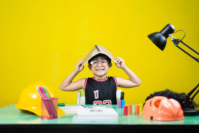 Portrait of a smiling boy against yellow wall