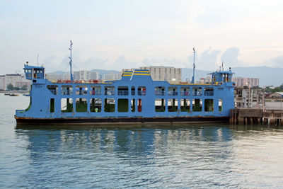 Nautical vessel on sea against sky in city