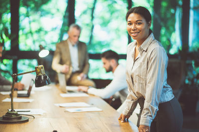 Portrait of young woman standing in office