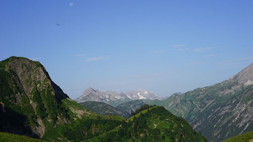 Scenic view of mountains against blue sky